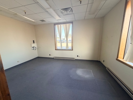 Interior photo of Suite 100. Yellow walls with a blue carpet and a window